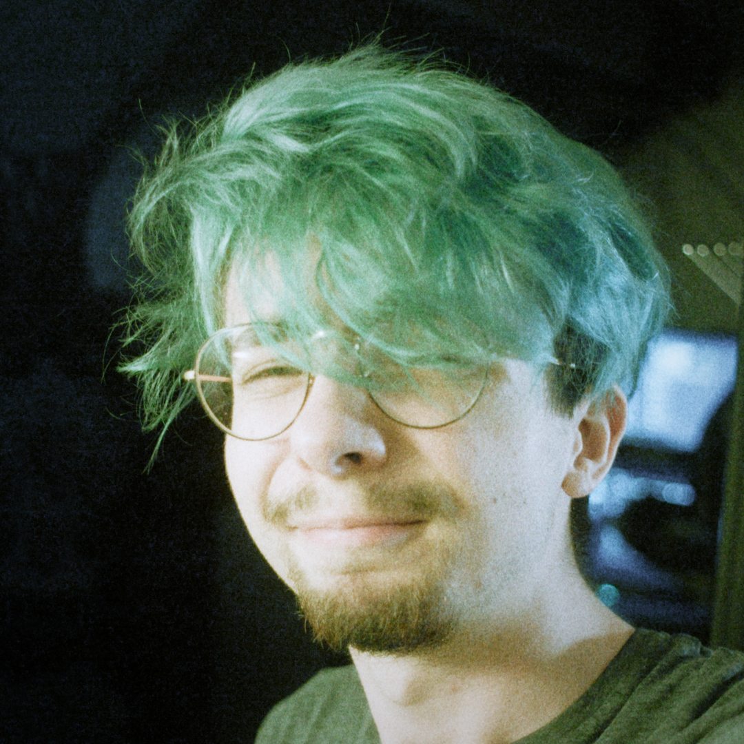 my profile picture; a portrait of a man with green hair and making a weird face. the image is overexposed with some green tints.